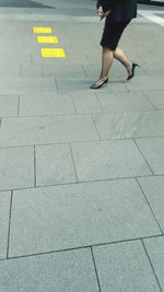 Low section of woman walking on zebra crossing