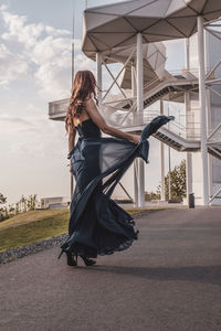 Woman with umbrella against sky