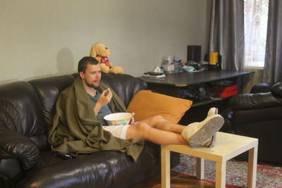 Friends sitting on sofa at home