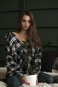 Portrait of young woman sitting at home