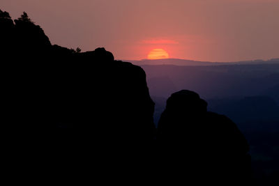 Silhouette rock formation against sky during sunset