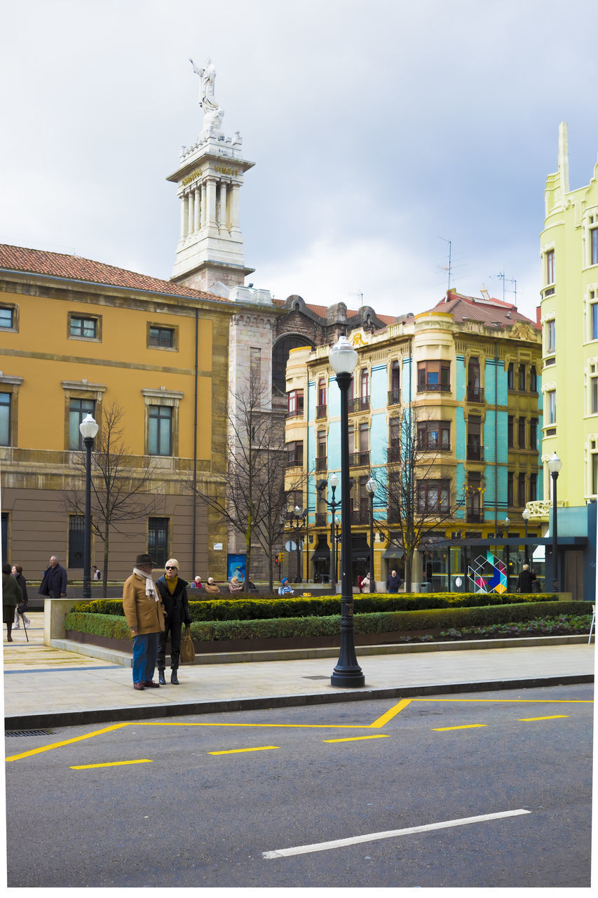 PEOPLE WALKING ON STREET AGAINST BUILDINGS