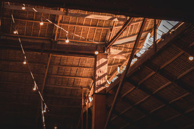 Low angle view of illuminated lights hanging on ceiling of building