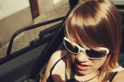 Woman wearing sunglasses while sitting in car