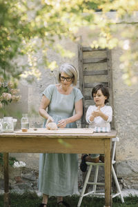 Full length of woman sitting on wooden table