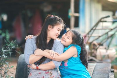 Happy mother and girl looking at camera