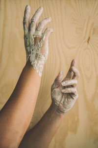 Close-up of woman with messy hands against wall