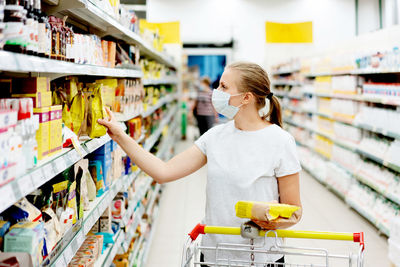 Woman wearing mask shopping in supermarket