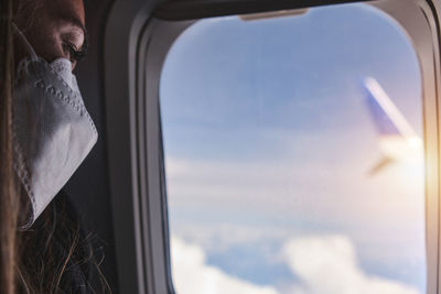 Woman looking at sky with clouds from the airplane window. sunset in the heights. woman face 