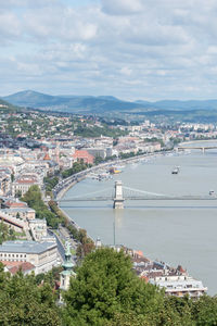 High angle view of cityscape by river against sky