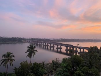 Bridge over river against sky during sunset