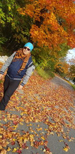 High angle view of woman by autumn leaves on tree