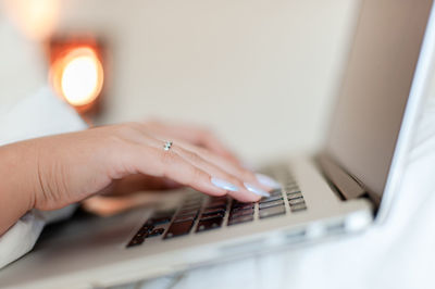 Cropped hands using laptop at home