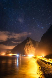 Scenic view of illuminated mountains against sky at night