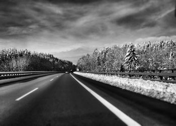 Empty road against cloudy sky