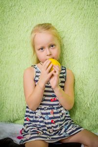 Portrait of baby girl lying on bed at home