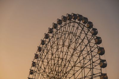 Low angle view of ferris wheel against sky during sunset