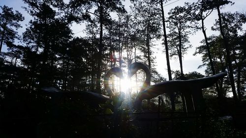 Low angle view of silhouette trees against sky