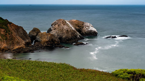 Scenic view of rocks in sea against sky