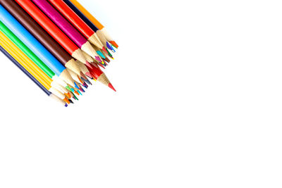 High angle view of colored pencils against white background