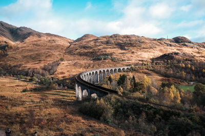 Glenfinnan viaduct bridge over mountain against sky