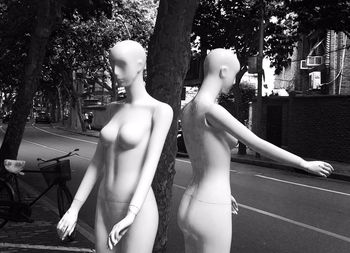 Mannequins by tree on street