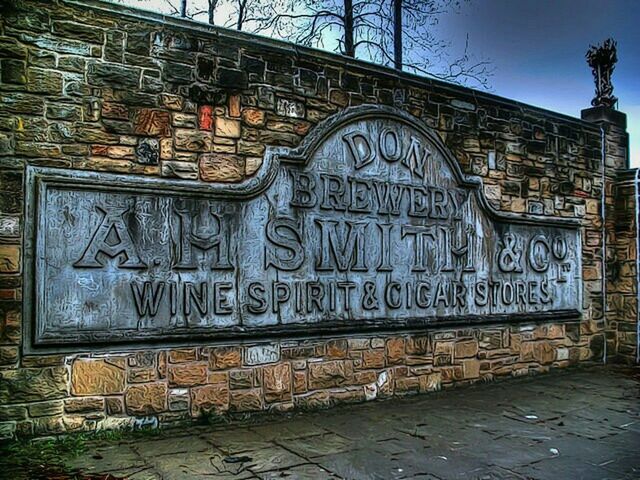 architecture, built structure, building exterior, text, graffiti, western script, communication, wall - building feature, outdoors, day, old, brick wall, no people, sky, street, capital letter, non-western script, city, art and craft, art