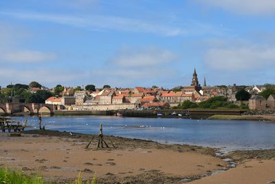 View of town by sea against sky