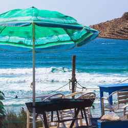 Chairs and tables on beach against sky