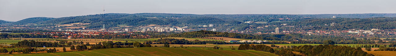 Scenic view of agricultural field by buildings against sky