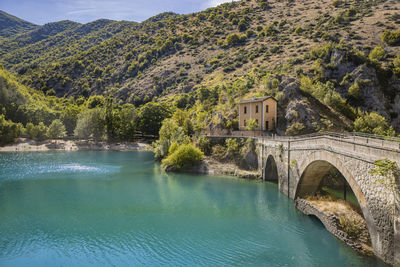 Bridge over river against mountain