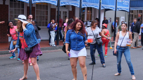 Group of people walking on road in city