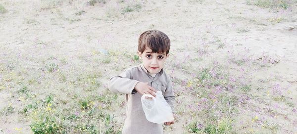 Portrait of boy standing against plants