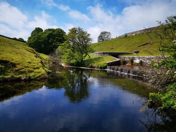 Arch bridge over lake against sky