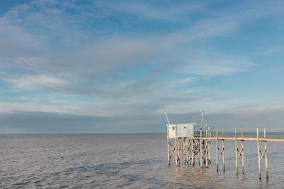 Scenic view of sea and fishing hut in charente maritime against sky