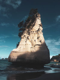 Rock formation in sea against sky