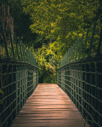 Rear view of man walking on footbridge