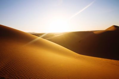 Scenic view of desert against sky during sunset