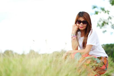 Portrait of woman in sunglasses on field