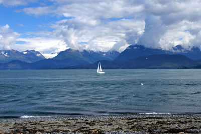 Scenic view of sea and mountains against sky