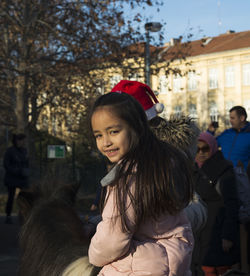 Portrait of girl riding pony on street in city