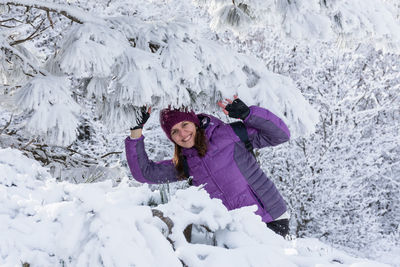 Young woman snow forest. a beautiful brunette enjoys the first fluffy clean snow near a snow-covered 