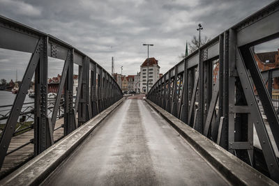 Bridge amidst buildings against sky in city