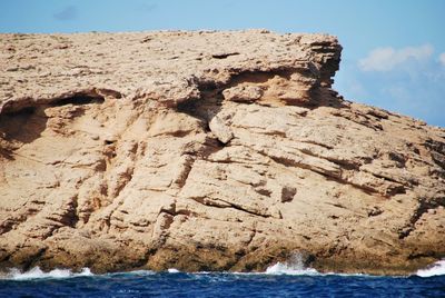 Rock formations on sea shore against sky