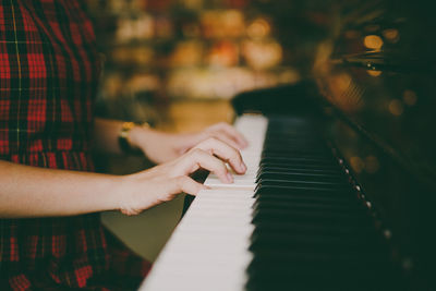 Midsection of young woman playing piano