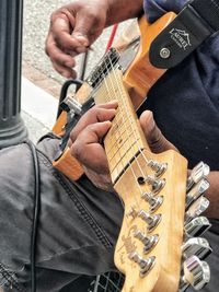 Midsection of man playing guitar