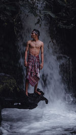 Full length of shirtless man standing in water