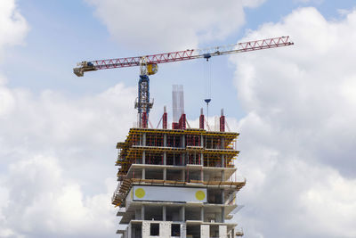 Low angle view of crane against sky