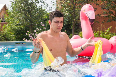 Full length of shirtless man in swimming pool