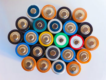 Directly above shot of multi colored batteries against white background